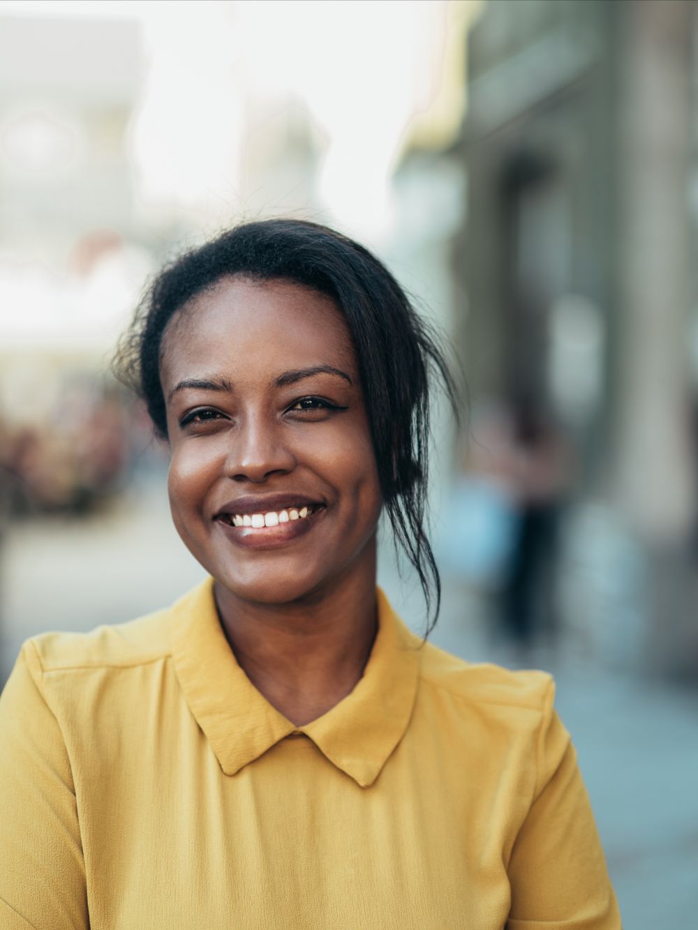 woman smiling in yellow blouse